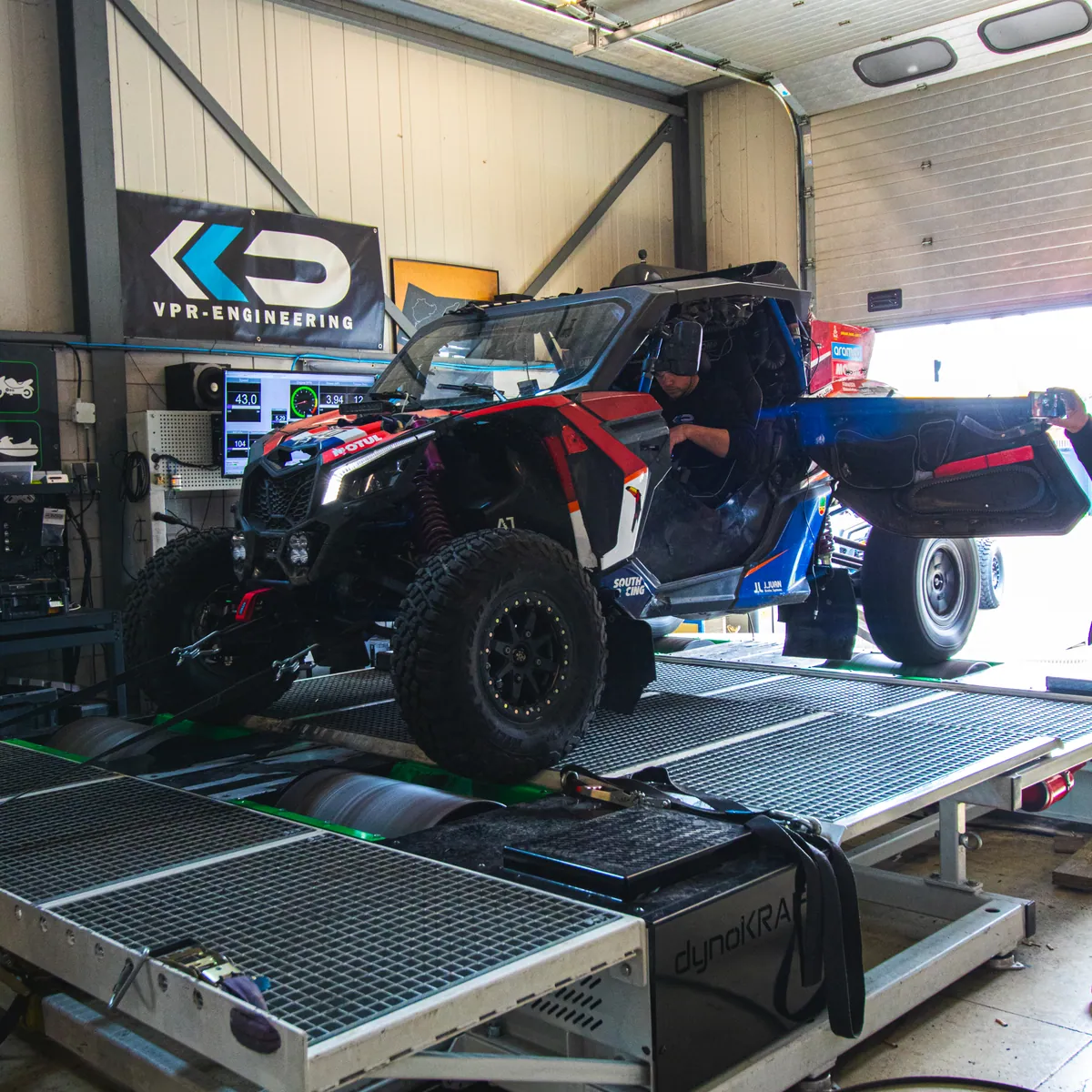 Een Dakar-rallybuggy vastgezet op de 4x4-rollenbank, met het telemetriescherm in beeld.