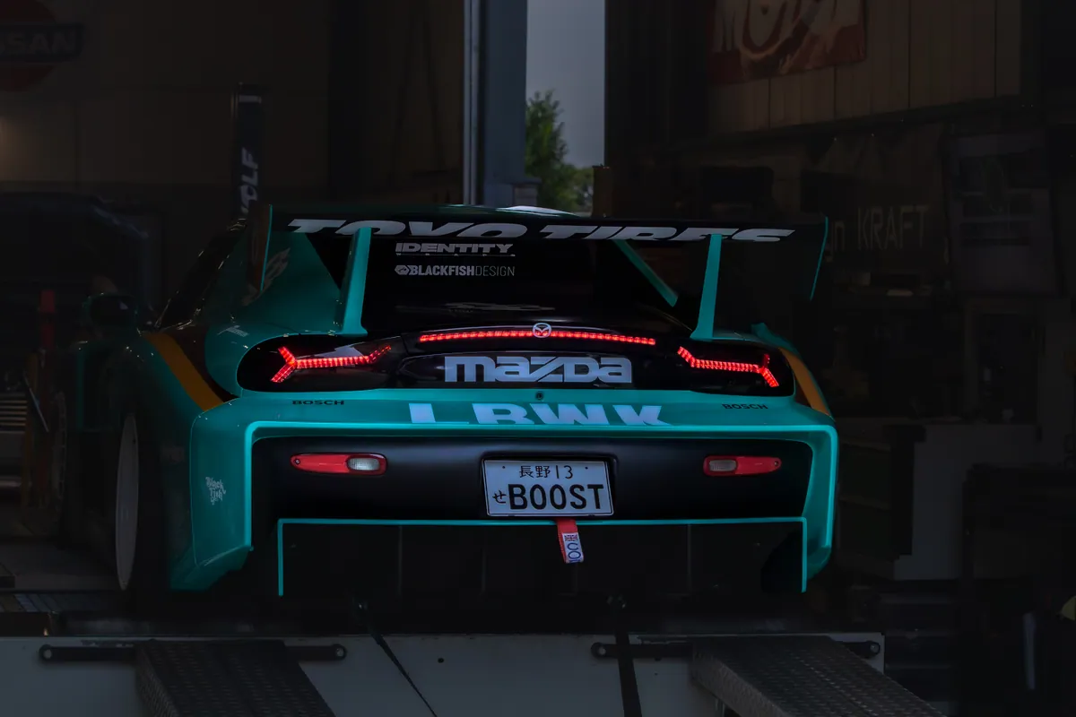 Turquoise Mazda RX-7, achteraanzicht met TOYO TIRES-vleugel.