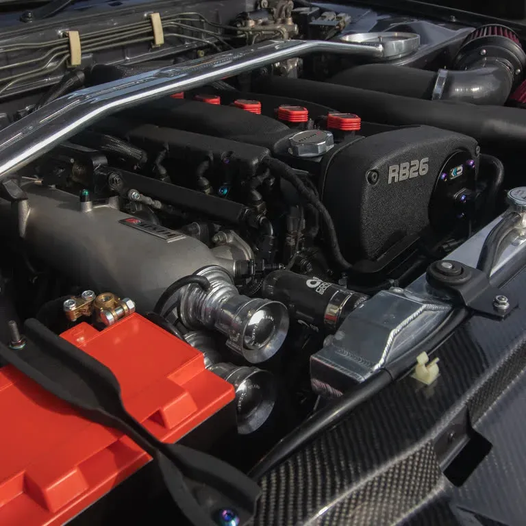Motorruimte van een Nissan Skyline GT-R (BNR32) met de RB26-motor en carbon strut brace.